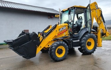 Ż&oacute;łta koparka stoi na placu gospodarczym