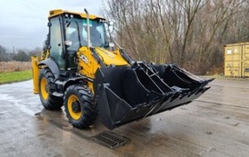 Ż&oacute;łta koparka stoi na placu gospodarczym