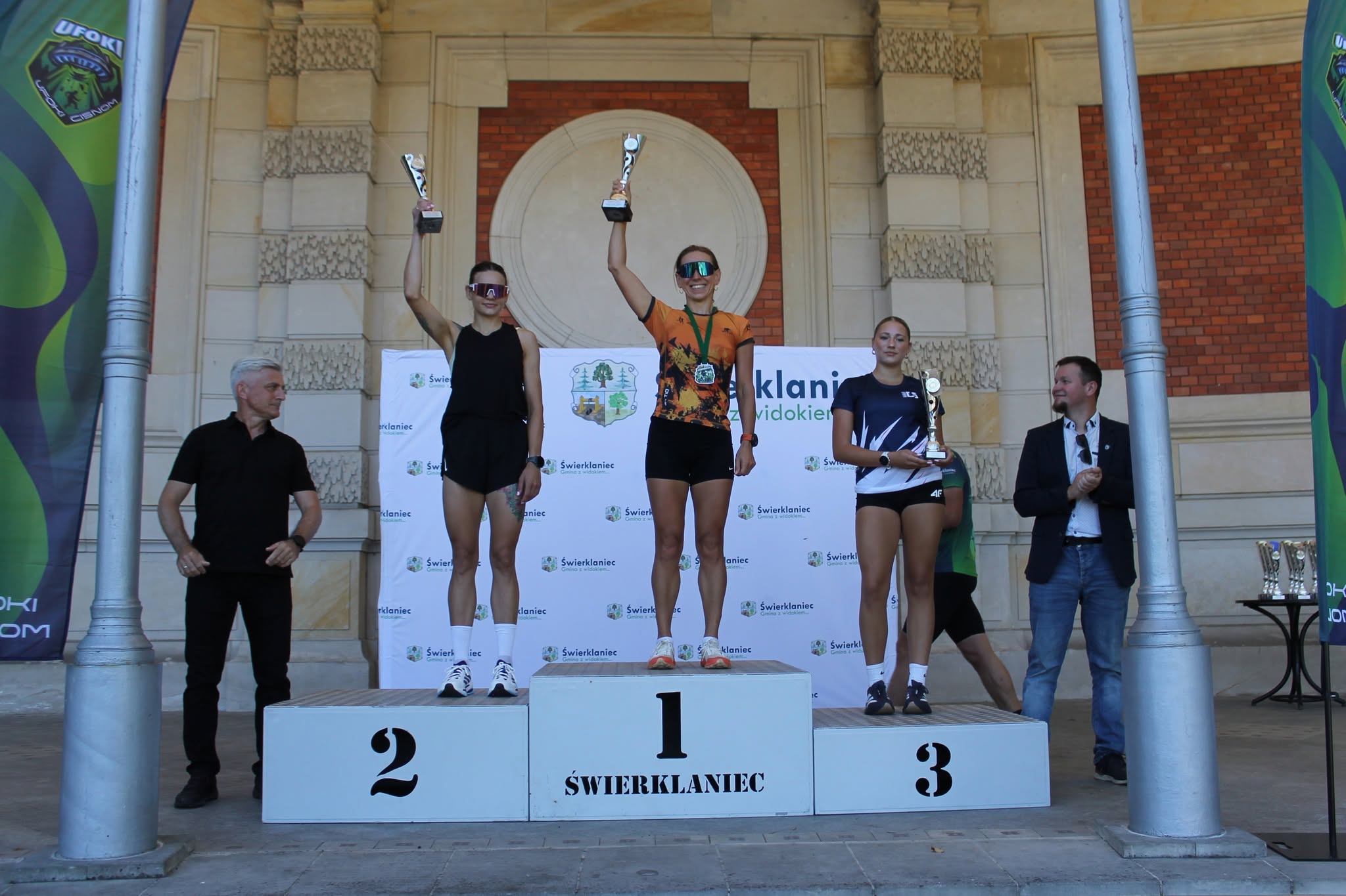 Najszybsze kobiety w&nbsp;biegu z&nbsp;pucharami uniesionymi wysoko na&nbsp;podium